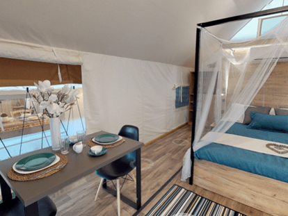 Luxuscamping - Art der Unterkunft: Safari-Zelt - Österreich - Lakeside romantic Tent Schlafzimmer mit Doppelbett und der Sitz- bzw. Essbereich - Lakeside Petzen Glamping Resort Lakeside romantic Tent im Lakeside Petzen Glamping Resort