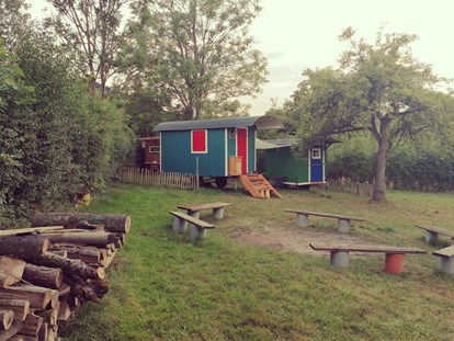 Luxuscamping - Unterkunft alleinstehend - Außenbereich mit Feuerstelle - Ecolodge Hinterland Bauwagen Lodge