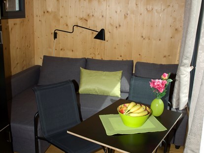 Luxuscamping - Art der Unterkunft: Mobilheim - Deutschland - Innenansicht der Minilodges. Die Sitzgruppe kann in ein bequemes Doppelbett umfunktioniert werden. - Camping Park Gohren Minilodges Camping Park Gohren
