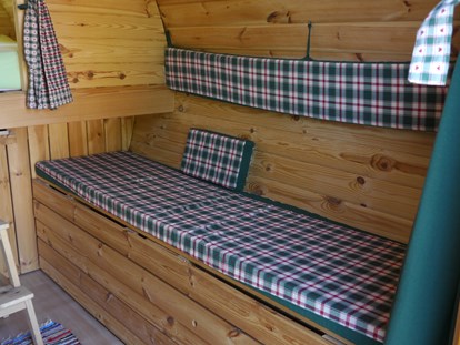 Luxuscamping - Terrasse - Deutschland - Die Bank lässt sich verbreitern, so dass ein Einzelbett entsteht auf dem auch ein Erwachsener liegen kann (2,10 x 0,70 cm). - Lech Camping Schlaf-Fass bei Lech Camping