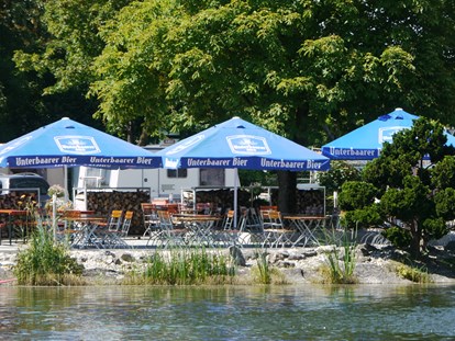 Luxuscamping - Preisniveau: günstig - Bayern - Hier ein Blick vom See auf die Seeterrasse unseres Restaurants. - Lech Camping Schlaf-Fass bei Lech Camping