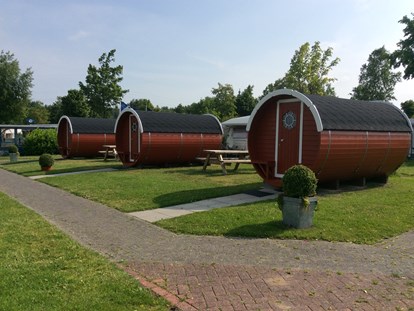 Luxuscamping - Ostfriesland - Camping-Schlaffässer am See. Die Fässer stehen in exklusiver Lage direkt am Badesee mit Blick aufs Wasser. - Freizeitpark "Am Emsdeich" Schlaffass mit Seeblick auf dem Freizeitpark "Am Emsdeich"