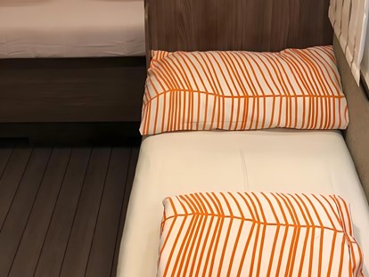 Luxuscamping - Preisniveau: gehoben - Umbau Sitzgruppe zum Einzelbett - camping-in-venedig.de -WMC BUSCHMANN wohnen-mieten-campen at Union Lido Deluxe Caravan mit Doppelbett / Dusche