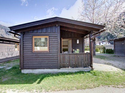 Luxury camping - Art der Unterkunft: Hütte/POD - Chalet Außenansicht - Frühling - Camping Brunner am See Chalets auf Camping Brunner am See
