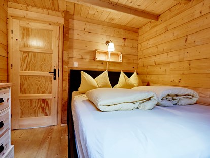 Luxury camping - Kühlschrank - Schlafzimmer mit Doppelbett - Camping Dreiländereck in Tirol Blockhütte Bergzauber Camping Dreiländereck Tirol