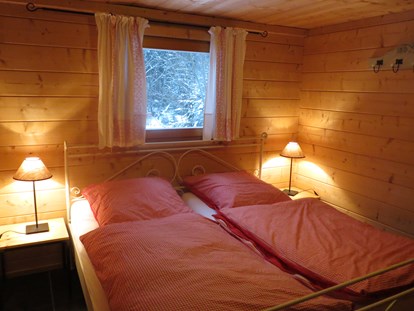 Luxury camping - Kühlschrank - Germany - Landhaus - Schlafzimmer mit Doppelbett - Camping Langenwald Blockhäuser auf Camping Langenwald