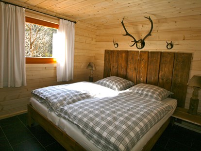Luxury camping - Kühlschrank - Germany - Jagdhütte - Schlafzimmer mit Doppelbett - Camping Langenwald Blockhäuser auf Camping Langenwald