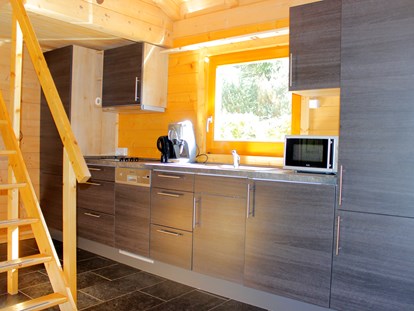Luxuscamping - Kühlschrank - Freudenstadt - Küchenzeile mit Kochgelegenheit, Spülmaschine, Mikrowelle und Kaffeemaschine - Camping Langenwald Blockhäuser auf Camping Langenwald