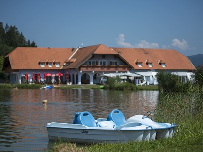 Luxuscamping - Umgebungsschwerpunkt: Berg - Österreich - Außenansicht Pension und Seerestaurant Pirkdorfer See mit dem Pirkdorfer See im Vordergrund. - Lakeside Petzen Glamping Resort