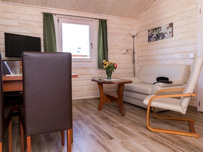 Luxury camping - gut erreichbar mit: Motorrad - Wohn- und Essbereich im Ferienhäuschen - Ostseecamping Ferienpark Zierow