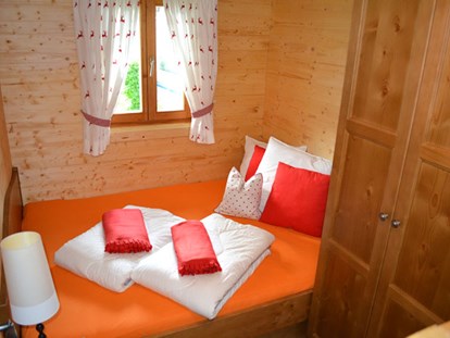 Luxuscamping - Lagerfeuerplatz - Ferienhütte "Schober": Schlafzimmer mit Doppelbett und einem Stockbett - CAMP MondSeeLand