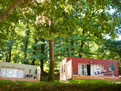 Luxuscamping - Art der Unterkunft: Mobilheim - Rhône-Alpes - Mobilheim Indigo - Aussenansicht mit Terrasse - Camping Huttopia Divonne Mobilheim Indigo auf Camping Huttopia Divonne