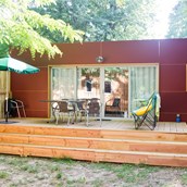 Luxuscamping: Mobilheim Indigo - Aussenansicht mit Terrasse  - Camping Huttopia Royat: Mobilheim Indigo auf Camping Huttopia Royat