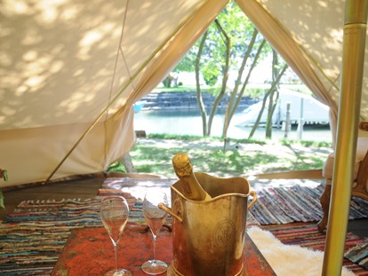 Luxury camping - Hunde erlaubt - Switzerland - Sicht auf den Zürichsee - Der Champagner ist bei einer Übernachtung im möblierten Zelt dabei. - Camping Zürich Safari-Zelt auf Camping Zürich