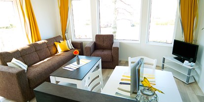Luxuscamping - Terrasse - Mecklenburg-Vorpommern - Wohnzimmer mit Sat-TV und gemütlicher Couch - Ostseecamp Seeblick Bungalow Möwe am Ostseecamp Seeblick