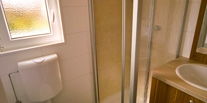Luxuscamping - Terrasse - Mecklenburg-Vorpommern - Modernes Bad mit Dusche, WC und Waschgelegenheit. - Ostseecamp Seeblick Bungalow Möwe am Ostseecamp Seeblick