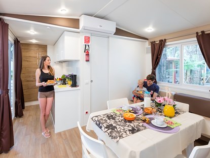 Luxuscamping - TV - Venedig - Wohnzimmer und Küche - Camping Ca' Pasquali Village Mobilheim Top Residence Platinum auf Camping Ca' Pasquali Village
