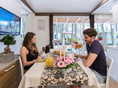 Luxuscamping - TV - Cavallino - Wohnzimmer und Küche - Camping Vela Blu Mobilheim Torcello Platinum auf Camping Vela Blu