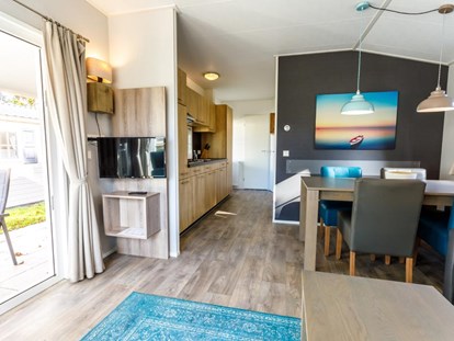 Luxuscamping - Preisniveau: gehoben - Blick in den Wohnbereich mit Küchenzeile im Chalet Campingplatz Pilsensee - Pilsensee in Bayern Mobilheime direkt am Pilsensee in Bayern