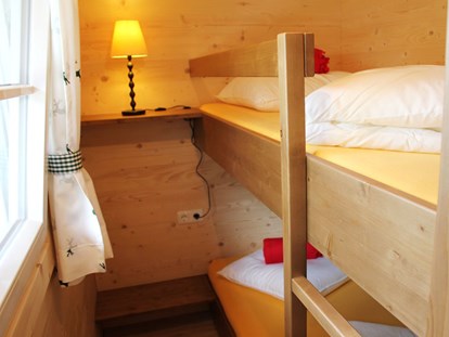 Luxury camping - Kochmöglichkeit - Ferienhütte "Schafberg": Kinderzimmer mit einem Stockbett - CAMP MondSeeLand Ferienhütten am CAMP MondSeeLand