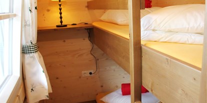 Luxuscamping - Ferienhütte "Schafberg": Kinderzimmer mit einem Stockbett - CAMP MondSeeLand Ferienhütten am CAMP MondSeeLand