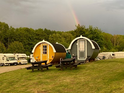 Luxury camping - Heizung - Ostseeküste - Die beiden Fässer am Eingang mit den dazugehörigen Gartenbänken - ostseequelle.camp Campingfässer (Schlafffässer)