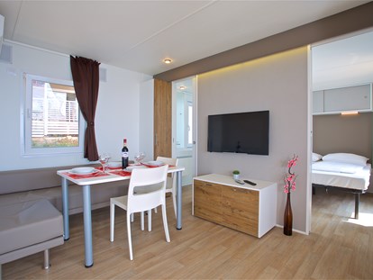 Luxury camping - Adria - Wohnzimmer mit Esstisch und Stühlen
 - Camping Cikat Mobilheime Typ C auf Camping Cikat