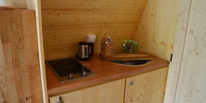 Luxuscamping - Kochmöglichkeit - Küche mit Kochplatten, Spüle und Kühlschrank mit Eisfach - Naturcampingpark Rehberge Glamping-Pod Waldemar am Wurlsee - Naturcampingpark Rehberge