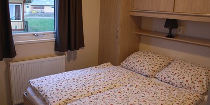 Luxuscamping - WC - Ostseeküste - Schlafzimmer mit Doppelbett im Mobilheim "Ocala" - Ostseecamping Ferienpark Zierow Mobilheime und Ferienhäuschen im Ostseecamping Ferienpark Zierow
