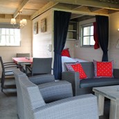 Luxuscamping: Wohnraum mit Küche und Schlafzimmer mit Doppelbett - Camping De Kleine Wolf: Ferienhütte Hooiberg auf Camping De Kleine Wolf