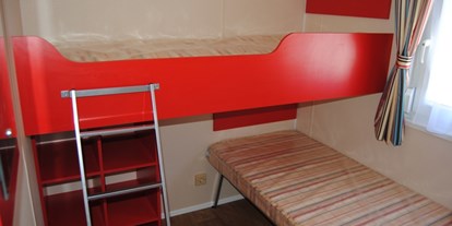 Luxuscamping - Kühlschrank - Luxemburg - 2 kleine Schlafzimmer mit jeweils 2 Einzelbetten (als schräg gestelltes Hochbett) - Camping Fuussekaul Luxus Mobilheime Normandy für 8 Personen auf Camping Fuussekaul