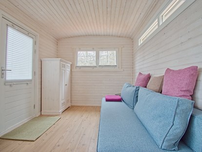 Luxuscamping - Preisniveau: gehoben - gemütliches Schlafsofa und Kleiderschrank - Naturcampingpark Rehberge Tiny House am See - Naturcampingpark Rehberge