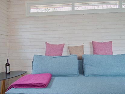 Luxuscamping - getrennte Schlafbereiche - Sitzecke mit Couchtisch - Naturcampingpark Rehberge Tiny House am See - Naturcampingpark Rehberge