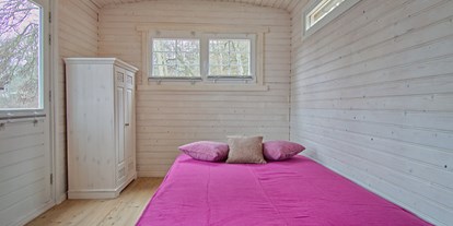 Luxuscamping - WC - ausgeklappte Schlafcouch - Naturcampingpark Rehberge Tiny House am See - Naturcampingpark Rehberge