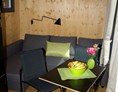 Glampingunterkunft: Innenansicht der Minilodges. Die Sitzgruppe kann in ein bequemes Doppelbett umfunktioniert werden. - Minilodges Camping Park Gohren
