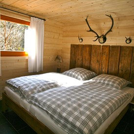 Glampingunterkunft: Jagdhütte - Schlafzimmer mit Doppelbett - Blockhäuser auf Camping Langenwald