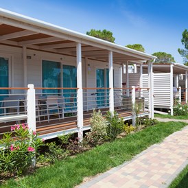 Glampingunterkunft: Außenansicht des Mobilheims mit Terrasse - Mobilheim Venezia Platinum auf Vela Blu Camping Village