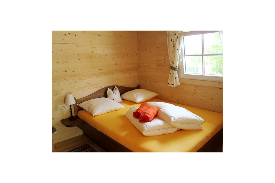 Glampingunterkunft: Ferienhütte "Drachenwand": Schlafzimmer mit Doppelbett - Ferienhütten am CAMP MondSeeLand