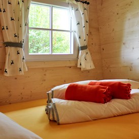 Glampingunterkunft: Ferienhütte "Schafberg: Schlafzimmer mit Doppelbett - Ferienhütten am CAMP MondSeeLand