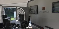 Luxuscamping - Seenplatte - Selbstverständlich sind alle Mietwohnwagen mit Vorzelt und Campingtisch samt Stühlen ausgestattet. - Naturcamping Malchow Wohnwagen auf Naturcamping Malchow