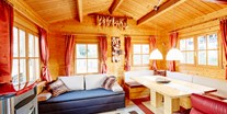 Luxuscamping - WC - Wohnbereich mit gemütlicher Sitzecke Pelletsofen, ausziehbarer Couch - Camping Dreiländereck in Tirol Blockhütte Tirol Camping Dreiländereck Tirol