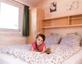 Glampingunterkunft: Schlafzimmer mit Doppel-Boxspringbett im Ferienhäuschen - Mobilheime und Ferienhäuschen im Ostseecamping Ferienpark Zierow