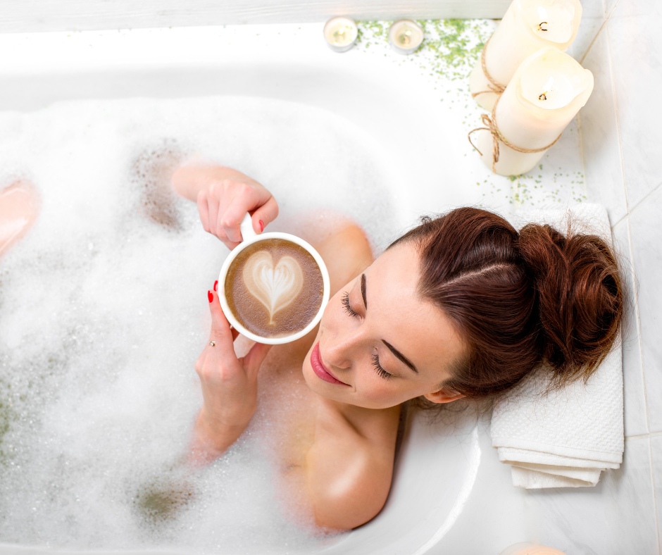 Frau liegt mit einer Kaffee-Tasse in der Badewanne