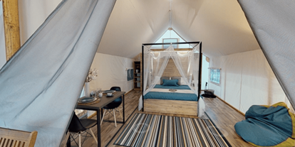 Luxuscamping - Savinjska - Lakeside romantic Tent Schlafzimmer mit Doppelbett, Schlafcouch und Essbereich - Lakeside Petzen Glamping Resort Lakeside romantic Tent im Lakeside Petzen Glamping Resort