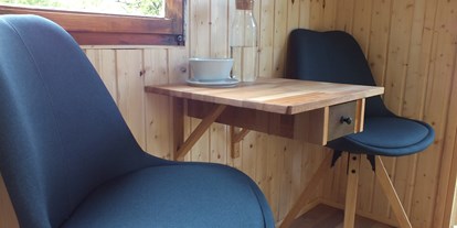 Luxuscamping - Kaffeemaschine - Sitz- und Essbereich im Blaumeischen - Ecolodge Hinterland Bauwagen Lodge