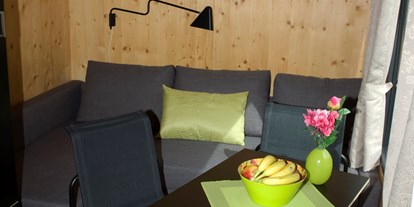 Luxuscamping - Kühlschrank - Region Bodensee - Innenansicht der Minilodges. Die Sitzgruppe kann in ein bequemes Doppelbett umfunktioniert werden. - Camping Park Gohren Minilodges Camping Park Gohren