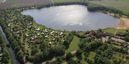 Luxuscamping - Terrasse - Ostfriesland - Luftaufnahme vom Campingplatz mit Badesee. - Freizeitpark "Am Emsdeich" Schlaffass mit Seeblick auf dem Freizeitpark "Am Emsdeich"