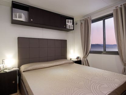 Luxuscamping - Mittelmeer - Mobilheim Next - Schlafzimmer mit Ehebett - Camping dei Fiori  Mobilheim Superior Next auf Camping dei Fiori 