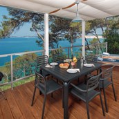 Glampingunterkunft: große und überdachte Terrasse mit einem Außensofa, Liegestühlen und einem wunderschönen Meerblick - Mobilheim Premium Vista Mare auf Lanterna Premium Camping Resort