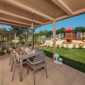Luxuscamping: Spacious and covered terrace with barbeque - Mobilheim Mediterannean Garden Premium auf Lanterna Premium Camping Resort